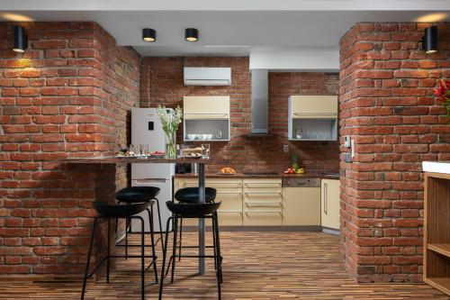 kuchnia z ceglaną ścianą i stołkami barowymi w obiekcie Old Town Apartment Spilberk by Goodnite cz w mieście Brno