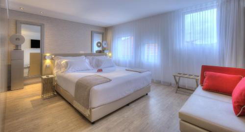 Un dormitorio con una gran cama blanca y un sofá. en NH Collection Porto Batalha, en Oporto