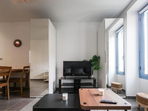 un salon avec une table et une télévision dans l'établissement Renovated 2 rooms Monaco border, à Beausoleil