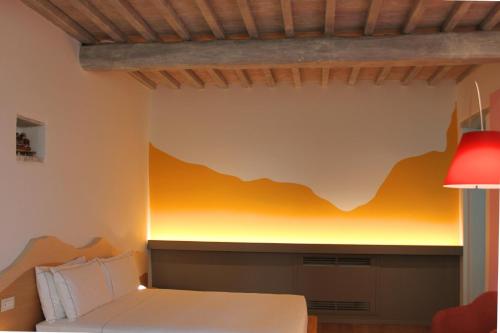 a room with a bed and a yellow wall at Mastrojanni Relais in Montalcino