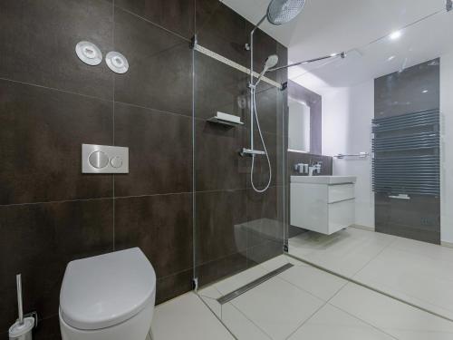 a bathroom with a toilet and a glass shower at Strandliebe - 5 Sterne Ferienwohnung - Urlaub zwischen Ostsee und Bodden in Wustrow