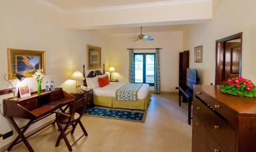 a hotel room with a bed and a desk and a computer at Sawai Madhopur Lodge - IHCL SeleQtions in Sawāi Mādhopur