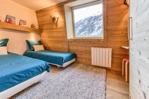 une chambre avec deux lits et une fenêtre dans l'établissement Apt Le Lyret, à Chamonix-Mont-Blanc