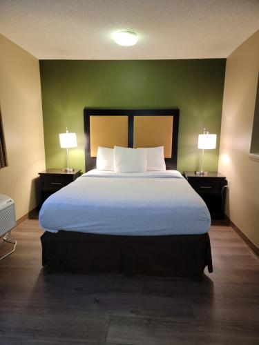 a bedroom with a large bed with two lamps at Suburban Studios-Cary in Cary