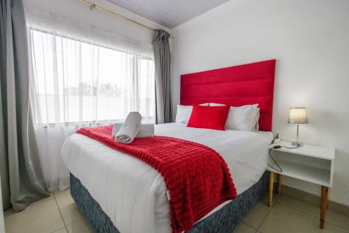 Un dormitorio con una cama grande con cabecero rojo. en Safi Elegant Self-catering Suite 5, en East London