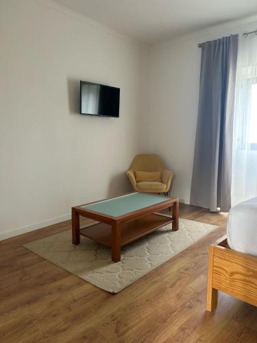 a living room with a coffee table and a chair at Vila Rosario in Ponta Delgada
