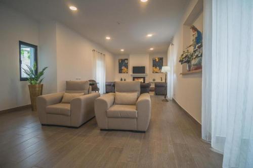 a living room with two chairs and a couch at Vila Rosario in Ponta Delgada