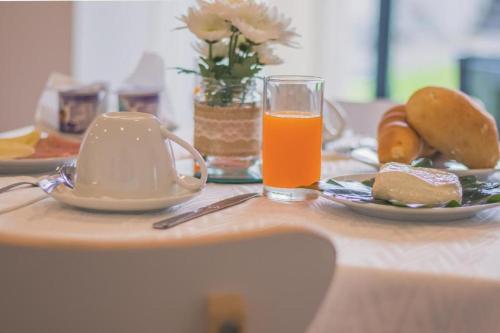 a table with a plate of food and a glass of orange juice at Vila Rosario in Ponta Delgada