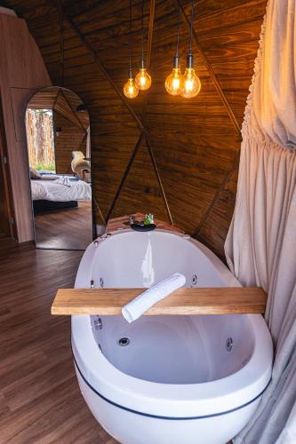 a bath tub in a room with a mirror at Le Refuge Urubici in Urubici