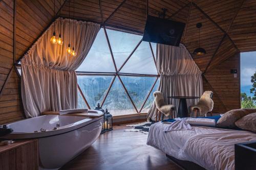 a bathroom with a tub and a large window at Le Refuge Urubici in Urubici