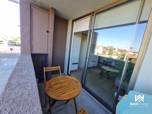 a room with a chair and a balcony at Departamento Corporativo II Talca Las Rastras ' Valles del Country - RENTCOVAC - Factura Inmediata in Talca