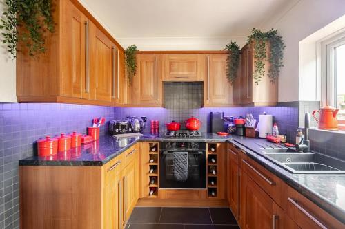 a kitchen with wooden cabinets and a black stove top oven at Bryn Derwen in Caernarfon