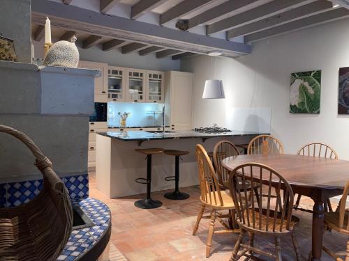 une cuisine et une salle à manger avec une table et des chaises dans l'établissement Le Gîte de la Forteresse de Berrye, à Berrie