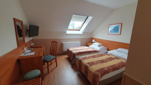 Pokój hotelowy z 2 łóżkami i biurkiem w obiekcie Hotel Baross w Győr