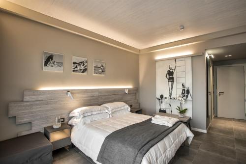 a bedroom with a large bed with a wooden headboard at Nautilus Family Hotel in Pesaro