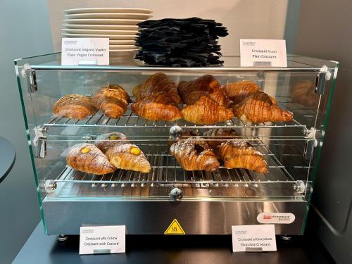 a display case with croissants and other pastries at BB Hotels Smarthotel Bailey's in Rome