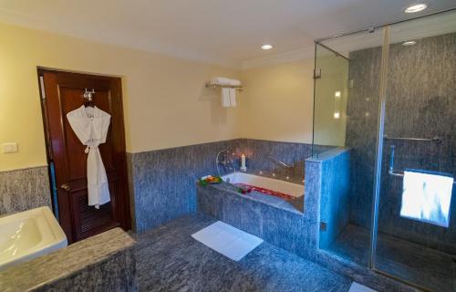 y baño con ducha, bañera y lavamanos. en Sawai Madhopur Lodge - IHCL SeleQtions, en Sawāi Mādhopur