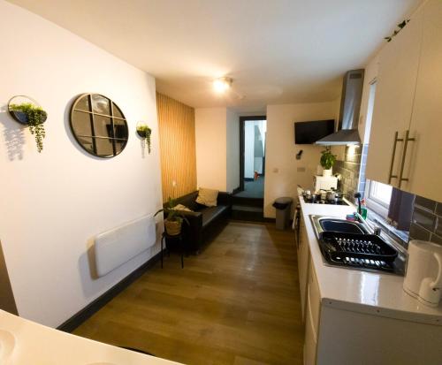 a kitchen with a counter and a living room at Mega Value Stay - 7 Beds, Keyless Entry, City 5 min walk BY PROPERTY PROMISE in Cardiff