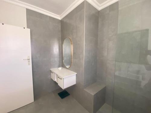 een badkamer met een wastafel en een spiegel bij Comfort & Style apartment 200m to beach with parking in Kaapstad