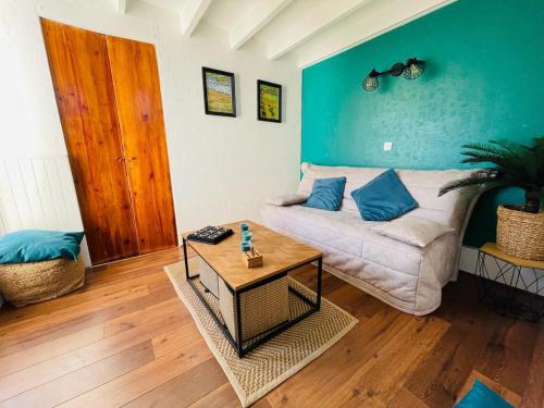 un salon avec un canapé et une table dans l'établissement Au Chant des Mouettes, à Cabourg