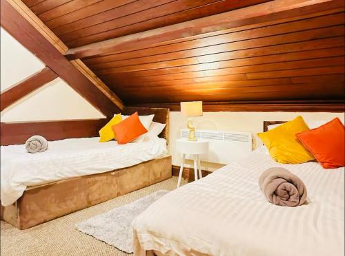 a bedroom with two beds and a wooden ceiling at Stacey's 4 Bedroom House in Pontypool in Pontypool