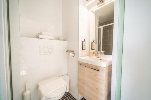 a white bathroom with a toilet and a sink at Centre Jean XXIII in Annecy