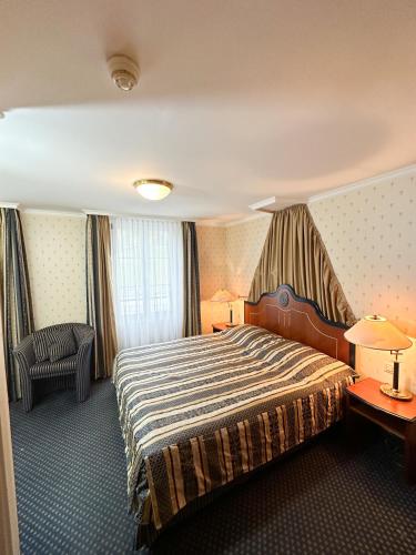 a hotel room with a bed and a chair at Room's at HAUS am SEE direkt am Thunersee gelegen mit SELF CHECK IN & digitaler Rezeption in Oberhofen am Thunersee
