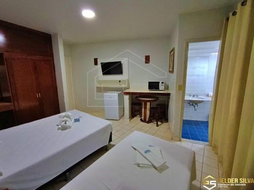 a hotel room with a bed and a desk at ARARAS Apart Service (centro) in Caldas Novas
