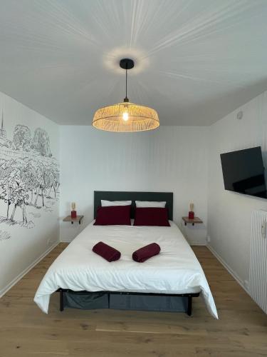 une chambre avec un grand lit blanc avec des oreillers rouges dans l'établissement Le Pinot - Centre-ville - Gare à 5 mn, à Dijon