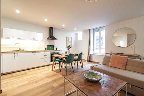 une cuisine et un salon avec un canapé et une table dans l'établissement La Suite rue Noël, à Reims