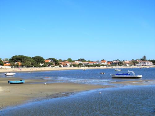 une plage avec des bateaux dans l'eau et une plage dans l'établissement Maison Flots & Sel 6 personnes proche plage, à Andernos-les-Bains