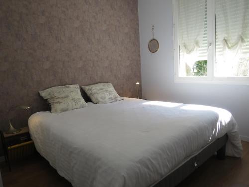 une chambre avec un lit blanc avec une fenêtre dans l'établissement Maison Flots & Sel 6 personnes proche plage, à Andernos-les-Bains