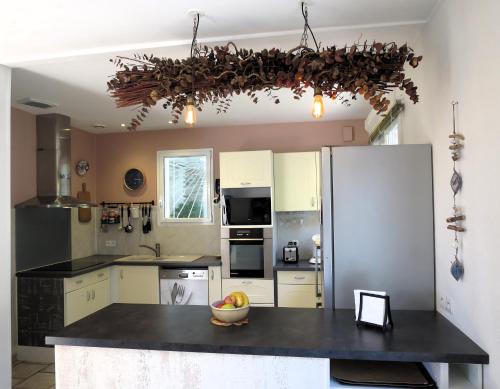 Il comprend une cuisine équipée d'un comptoir noir et d'un réfrigérateur. dans l'établissement Maison Flots & Sel 6 personnes proche plage, à Andernos-les-Bains