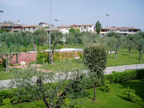 a view of a park with trees and a tennis court at Poggio al sole in Manerba del Garda