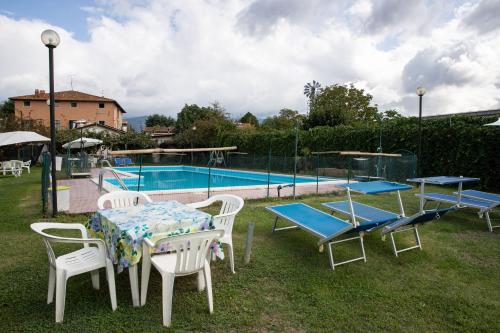 a group of tables and chairs next to a pool at Agriturismo Il Giardino in Sansepolcro