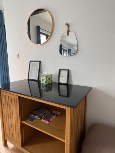 une table avec un miroir sur un mur dans l'établissement Nouveau - Le petit Auguste - 2ch - Port de plaisance, au Havre