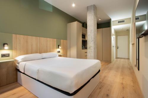 a bedroom with a large white bed in a room at Ola Living Chamartín Studios in Madrid
