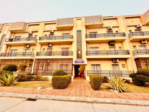 a large yellow building with balconies on it at Pearl Grand Boutique Cottage in Omaxe Anandam Vrindavan - #premium AC rooms with balcony #big parking #lift #garden #peaceful area #near prem mandir #property of the year #most awarded in Vrindāvan