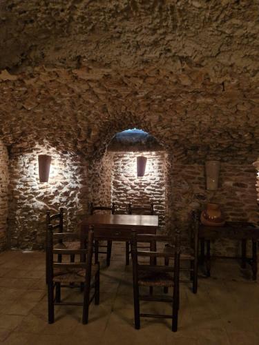 a room with a table and chairs in a stone wall at El Granero de Manzanares in Manzanares
