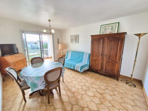 un salon avec une table et des chaises et une chambre dans l'établissement Appartement 1 chambre, climatisation, proche plage, tout à pied, à Sanary-sur-Mer