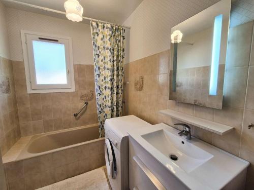 une salle de bain avec un lavabo, une baignoire et un miroir dans l'établissement Appartement 1 chambre, climatisation, proche plage, tout à pied, à Sanary-sur-Mer