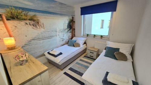 a small room with two beds and a window at RIVERS Apartment in Kołobrzeg