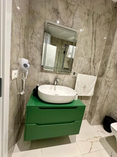 a bathroom with a green sink and a mirror at EKAM Sun Apartments in Golem