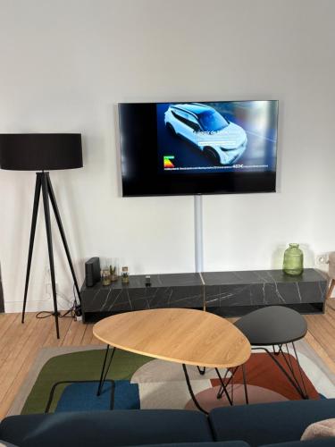 un salon avec une télévision à écran plat au mur dans l'établissement Nouveau - Le petit Auguste - 2ch - Port de plaisance, au Havre