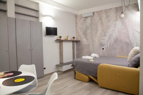 a bedroom with a bed and a table and a table and chairs at RRRapido Home in Brera - Via Mercato in Milan