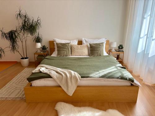 a large bed with a green blanket and pillows at Residence Caesar by Homester in Brno