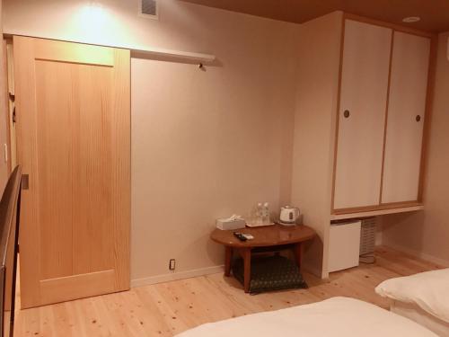 a bedroom with a table and a cupboard at skホテル in Ichibachō
