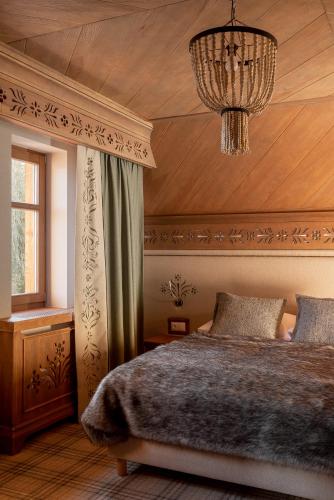a bedroom with a bed and a chandelier at Willa na Kozińcu in Zakopane
