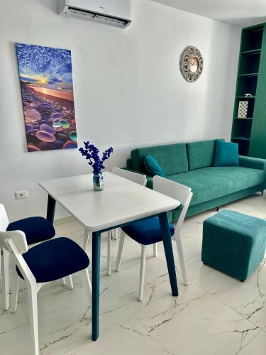 a living room with a table and chairs and a couch at EKAM Sun Apartments in Golem