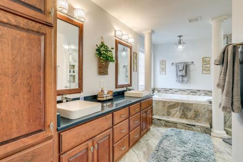 a bathroom with a tub and a sink and a tubermott at Deck and Gas Grill Riverfront Home in Heber Springs in Heber Springs